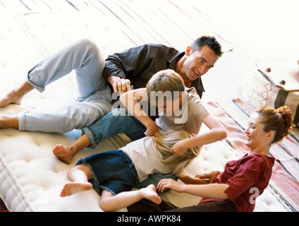 I genitori e i bambini che giocano sul materasso Foto Stock