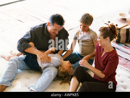 I genitori e i bambini che giocano sul materasso Foto Stock