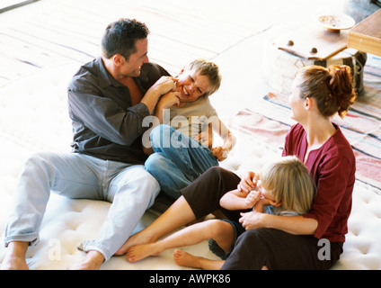 I genitori e i bambini che giocano sul materasso Foto Stock