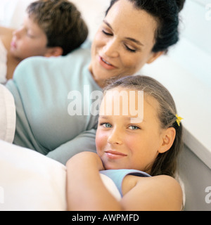 Madre giacente in letto tra i bambini Foto Stock