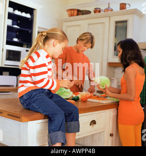 I bambini preparano la verdura in cucina Foto Stock