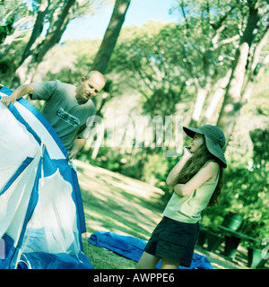 Uomo con tenda, ragazza sorridente Foto Stock