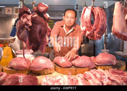 Mercato maschio commerciante tagli di carne viene offerto dal suo stallo phetchabun in Thailandia Foto Stock