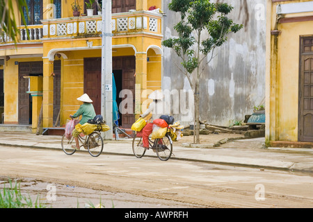 Due donne vietnamita passeggiate in bicicletta, Hoi An, Vietnam Asia Foto Stock