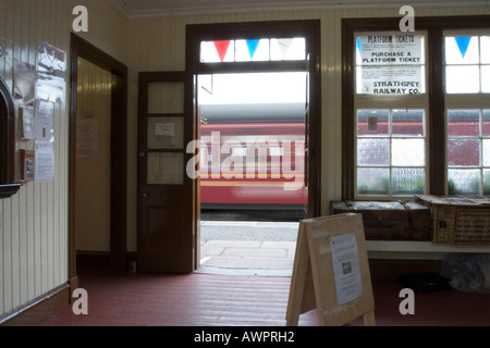 La stazione ferroviaria e il treno in movimento Foto Stock