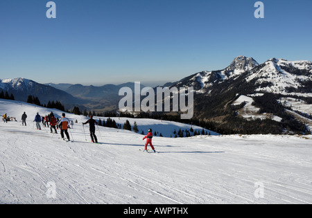 Gli sciatori a Sudelfeld Ski Resort, Wendelstein massiccio in background, Alpi Bavaresi, in Baviera, Germania, Europa Foto Stock