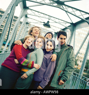 Un gruppo di giovani uomini e donne con le braccia intorno a ciascun altro Foto Stock