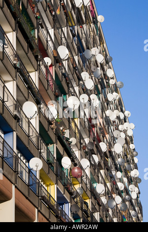 Un sacco di antenne paraboliche per la ricezione satellitare montato su balconi su un appartamento facciata di edificio, Pallasseum o 'Berlino Palazzo sociale' (Berliner S Foto Stock