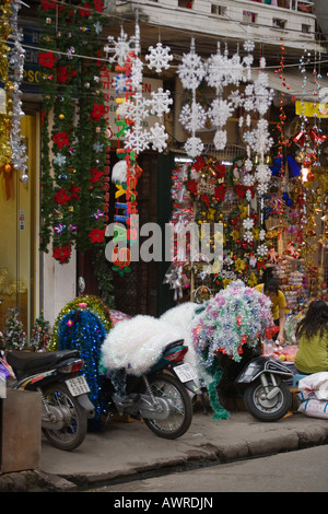 La carta Natale ornamenti appeso davanti a un negozio di Hanoi, Vietnam Foto Stock