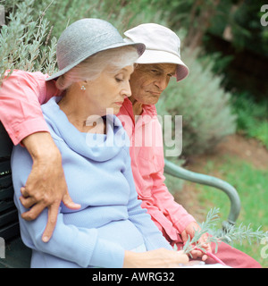 Coppia senior sedersi sulla panchina al di fuori Foto Stock