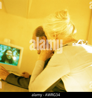 Senior l uomo e la donna guarda la schermata, vista posteriore Foto Stock