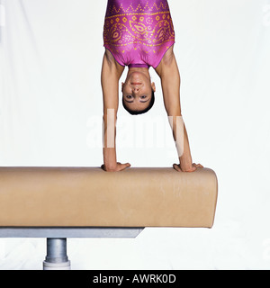 Ginnasta femmina facendo handstand sul cavallo Foto Stock