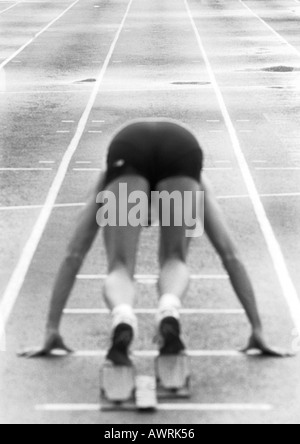 Runner maschio nel blocco di partenza, vista posteriore, b&W Foto Stock