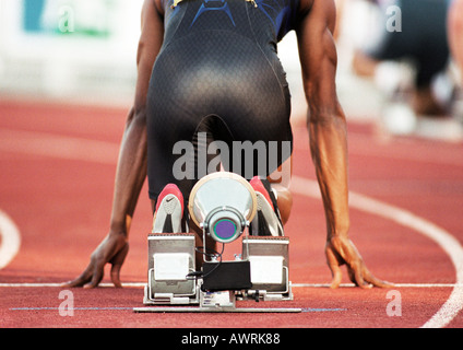 Runner maschio sul blocco di partenza, vista posteriore Foto Stock