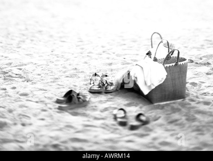 Borse e scarpe sulla spiaggia, b&w. Foto Stock