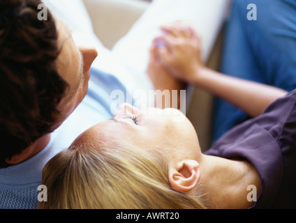 Donna pendente sulla testa di uomo della spalla, close-up Foto Stock