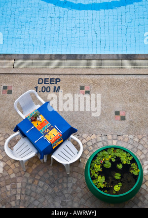 La colazione tavolo e sedie accanto ad una piscina in albergo, Phuket, Tailandia Foto Stock