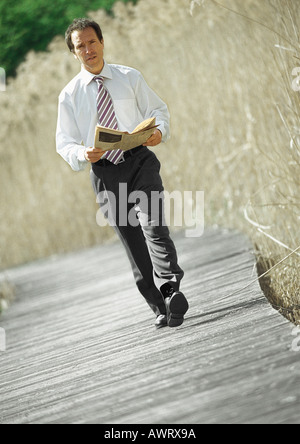Imprenditore a piedi con il giornale in mano, all'aperto, ritratto Foto Stock