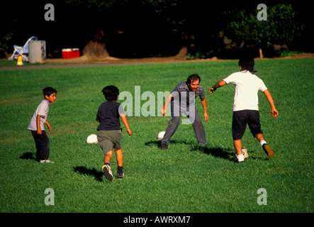 Giovani ragazzi ispanica di imparare a giocare a calcio da calci palla calcio mentre giocano a calcio in Pioneer Park nella città di Novato California Foto Stock