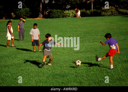 Giovani ragazzi ispanica di imparare a giocare a calcio da calci palla calcio mentre giocano a calcio in Pioneer Park nella città di Novato California Foto Stock