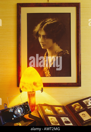 1920's vintage incorniciato ritratto di una giovane donna di album di foto di famiglia e piegatura antica fotocamera accesa da un 'Gallé' lampada Foto Stock