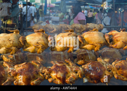 Polli essendo arrostito allo spiedo in un mercato di phetchabun thailandia Foto Stock