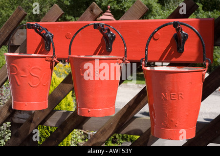 Tre secchi fuoco rossi sulla piattaforma della stazione sulla North Yorkshire Moors Railway a Levisham, North Yorkshire UK Foto Stock