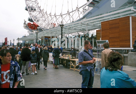 Rinforzo del popolo fino a salire sul London Eye ruota panoramica Ferris sotto la pioggia. Foto Stock