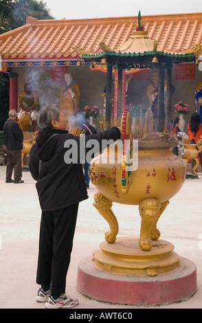 Dh il Monastero dei Diecimila Buddha SHATIN HONG KONG donna cinese burning joss bastoni urna lady incenso Foto Stock