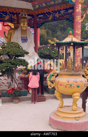 dh diecimila Buddha Monastero SHATIN HONG KONG ragazza cinese preghiera vecchia signora preghiera Dea statua incenso bruciatore culto Foto Stock