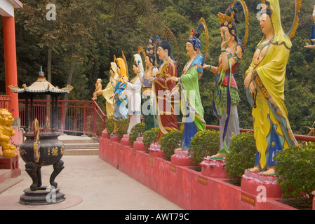 Dh il Monastero dei Diecimila Buddha SHATIN HONG KONG verniciato colorato statue rivolta verso l'ingresso del tempio e joss stick urn Foto Stock