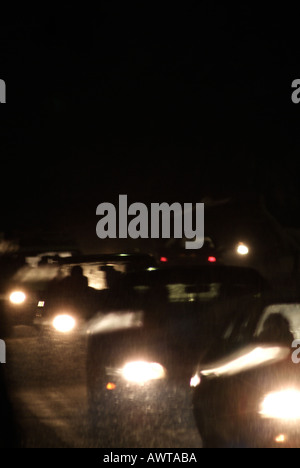 Auto su una strada di notte durante una tempesta di neve Foto Stock
