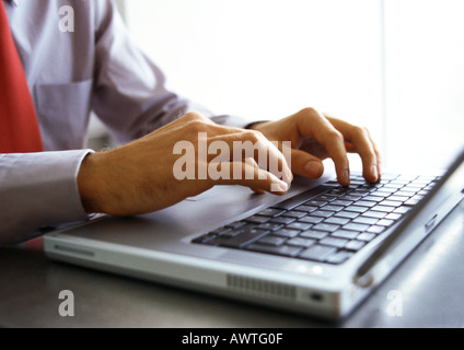 L'uomo le mani sulla tastiera del computer portatile Foto Stock