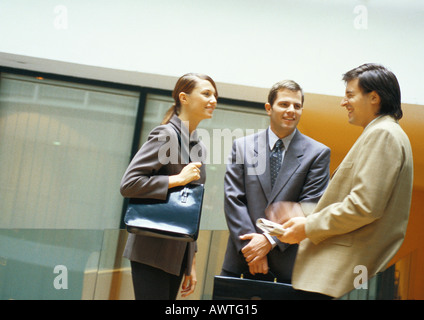 Tre gli imprenditori in piedi e sta parlando Foto Stock