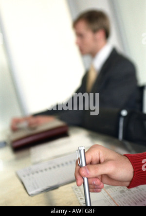 Imprenditore seduta a tavola, offuscata in distanza. Foto Stock