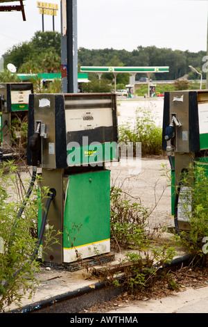 Vecchio gas abbandonata la stazione di benzina con un nuovo stabilimento in background distanti Foto Stock