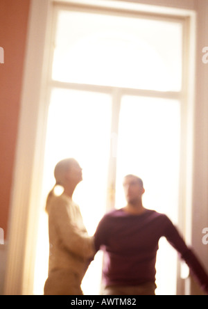 Donna e uomo in piedi di fronte alla finestra, offuscata, inclinazione. Foto Stock