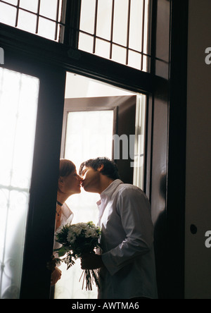 Baciare uomo donna in porta, inclinazione Foto Stock