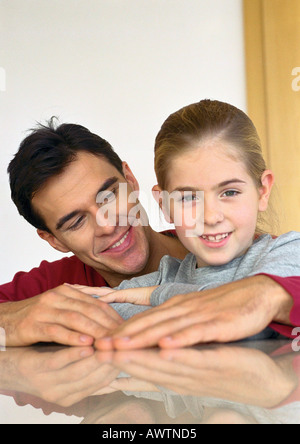 Padre seduto con la figlia, bracci avvolti intorno a lei. Foto Stock