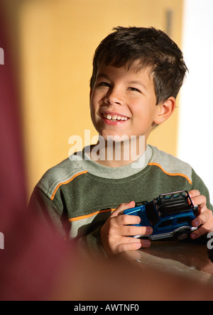 Bambino azienda giocattolo auto, guardando verso l'alto. Foto Stock