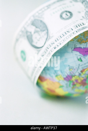 Un dollaro avvolta intorno al globo, close-up Foto Stock