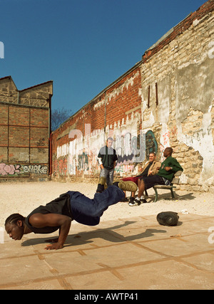 Uomo in equilibrio su mani, break dancing in contesto urbano Foto Stock