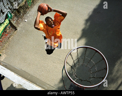 L'uomo salendo per una partita di basket dunk, girato da sopra Foto Stock
