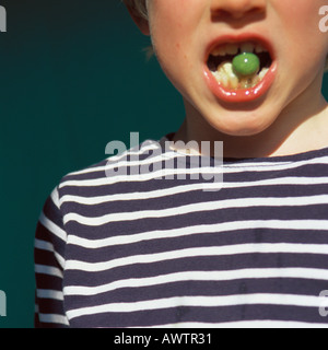 Bambino azienda gumball in bocca aperta Foto Stock