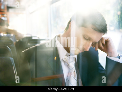 Imprenditore con la testa in giù sul bus Foto Stock