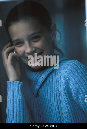 Giovane ragazza sul telefono sorridente, close up Foto Stock