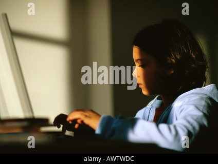 Giovane ragazza seduta, digitando su laptop Foto Stock