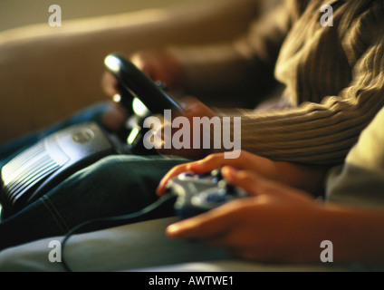 Mani di bambini che giocano con i video game, close up Foto Stock