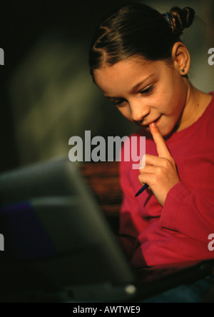 Ragazza giovane guardando giù al computer, chiudere fino Foto Stock