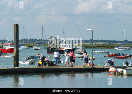 Famiglie di West Mersea che utilizzano un pontile galleggiante per la pesca delle granchi in una giornata di sole nell'Essex, Inghilterra, Regno Unito Foto Stock